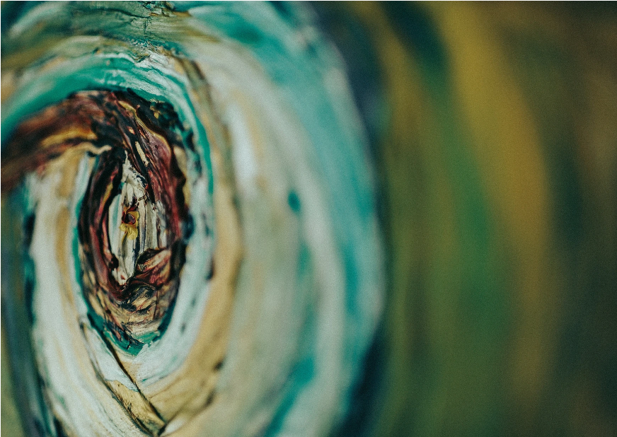 Close-up detail of an abstract painting featuring layered circular brushstrokes in teal, cream, and earthy tones, creating depth and movement.