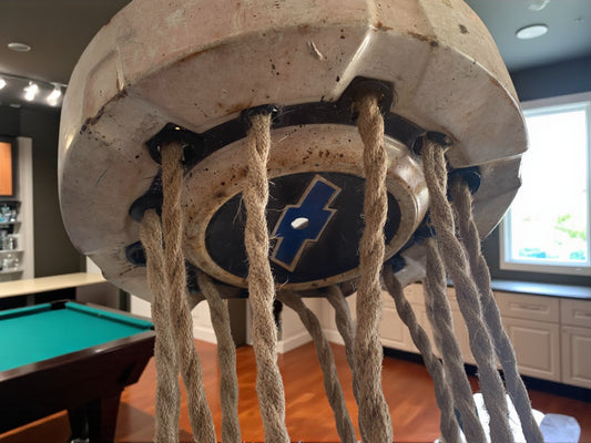 Vintage hubcap pendant light with Edison bulbs and rope cords suspended in a room.