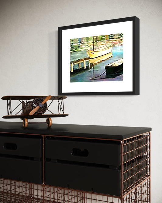 A framed coastal art print of a dock with a small boat reflected in calm water hangs on a light textured wall. Below, a modern wire set of drawers with a miniature sculpture of a vintage airplane.  The scene combines modern drawers, with a sea dock print and antique accents, creating a calm, classic atmosphere with a subtle coastal influence.