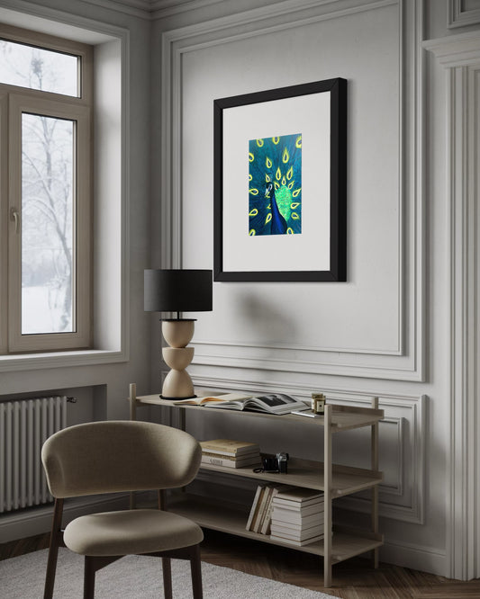 A refined interior featuring a framed peacock art print with vibrant blue and green feathers displayed on a decorative wall panel. Below, a modern, minimal light wood shelving unit holds books, a modern sculptured lamp, and decor. A soft contemporary upholstered chair sits nearby, and natural light filters through a window, creating a calm, elegant, and inviting atmosphere.  Great for any modern space. 