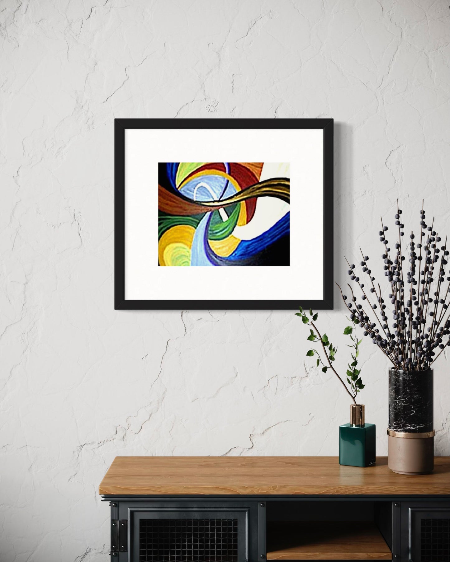 A contemporary dining space with a framed abstract art print featuring colorful flowing swirl shapes in multi color blue, yellow, red, and brown tones on a white brick wall. Below, a banquet dining table with two vases and dried plants.   Creating a warm, modern atmosphere with an artistic focal point.  Great for restaurants, bars, or home decor.  
