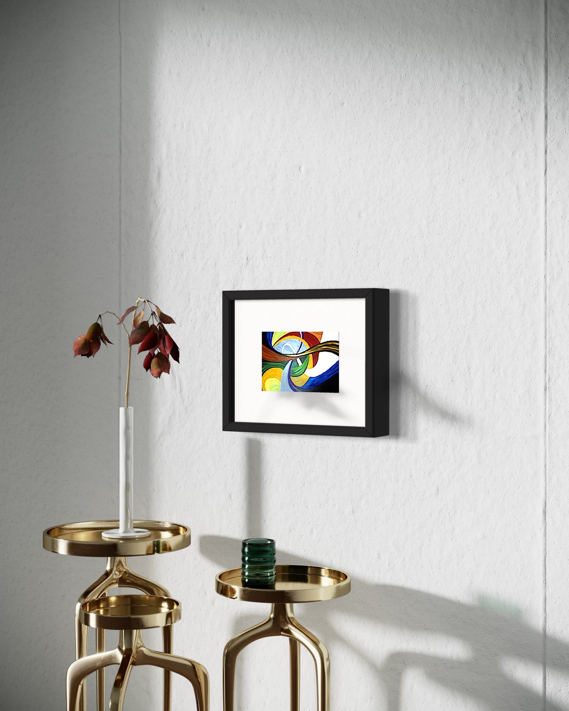 A contemporary living space with a framed abstract art print featuring colorful flowing swirl shapes in multi color blue, yellow, red, and brown tones on a white wall. Below, several brass multi level tables that have a vase with flowers.  Creating a warm, modern atmosphere with an artistic focal point.  Great for restaurants, bars, or home decor.  