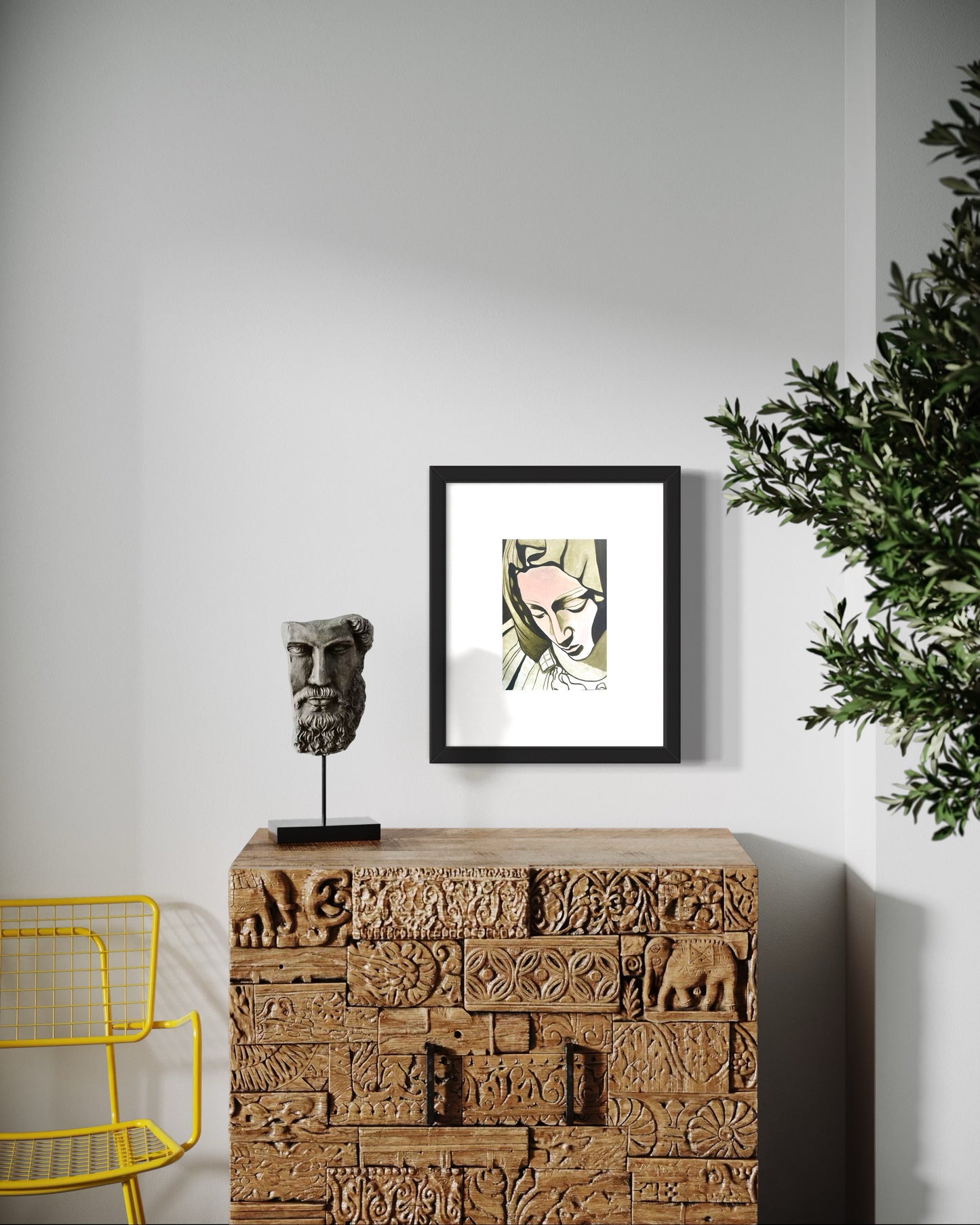 Modern interior with asian indian wood cabinet, yellow wire chair, a small roman sculpture, and framed artwork on a  white wall.  A minimalist interior featuring a framed portrait print of Mother Teresa, inspired by the Pieta sculpture in Rome, in muted green and flesh tones. The modern decor coupled with the nostalgia of Mother Teresa creates a calm, elegant, and contemplative atmosphere with a modern artistic touch.